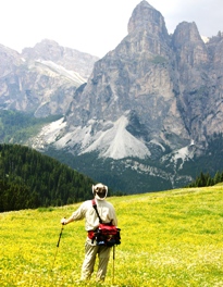 Hiker in field of wildflowers in the Dolomites