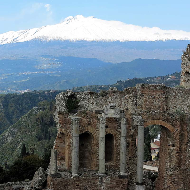 Greek theatre in Taormina with Mt. Etna volcano in background