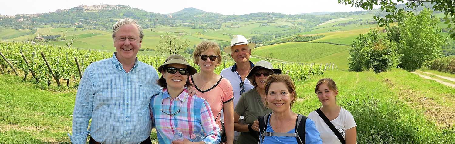 smiling tourists in front of lush, Italy landscape