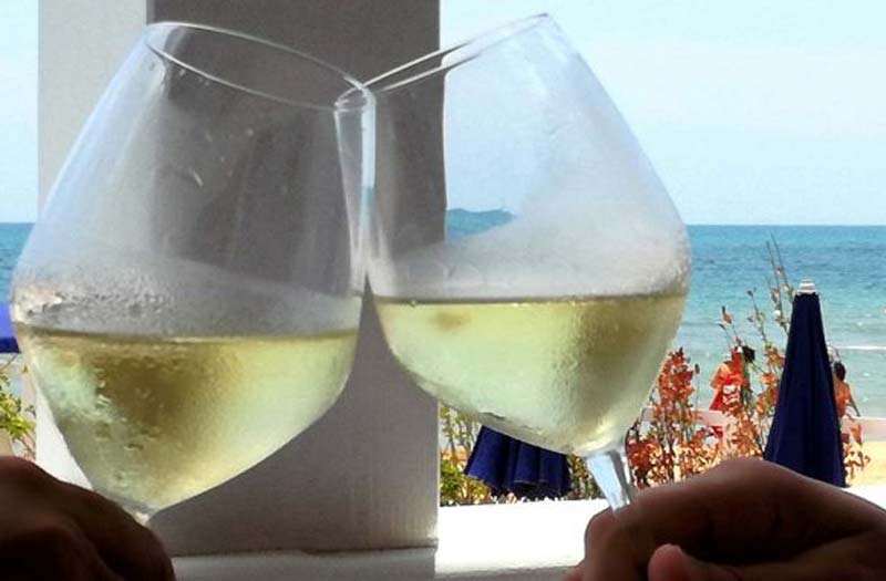 Glasses of white wine by the sea