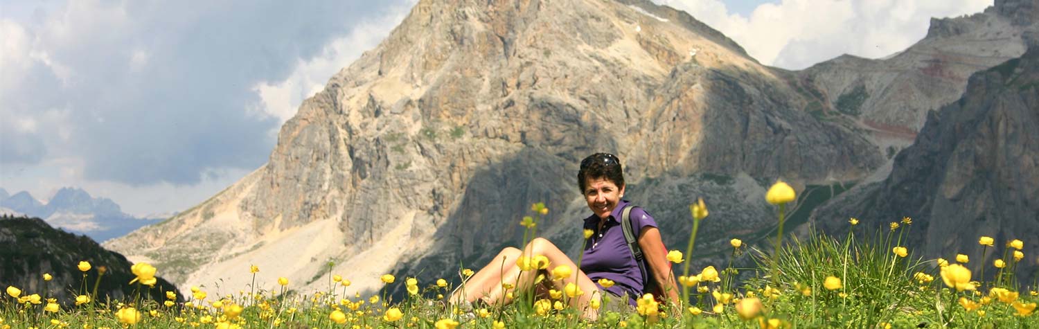 Woman resting in filed of wildflowers in the Dolomites