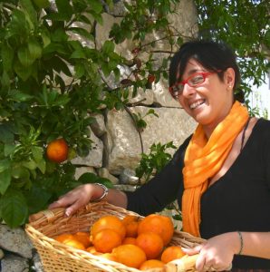 Lady with basket of fresh oranges in Sicily